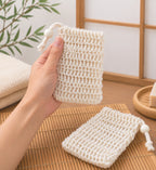 Main tenant un filet à savon en fibres naturelles dans une salle de bain japonaise