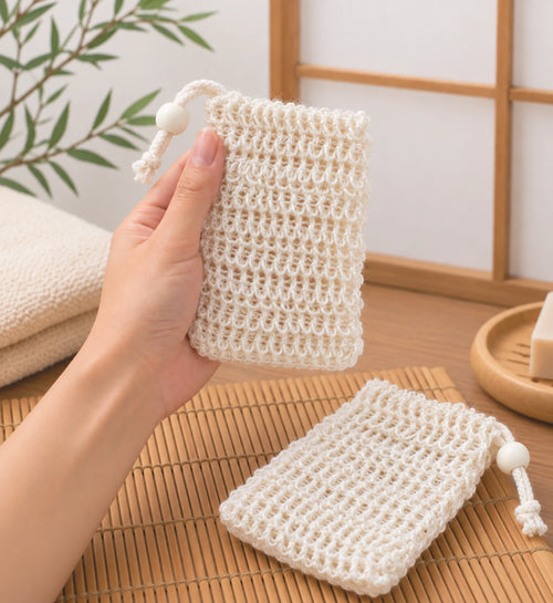 Main tenant un filet à savon en fibres naturelles dans une salle de bain japonaise