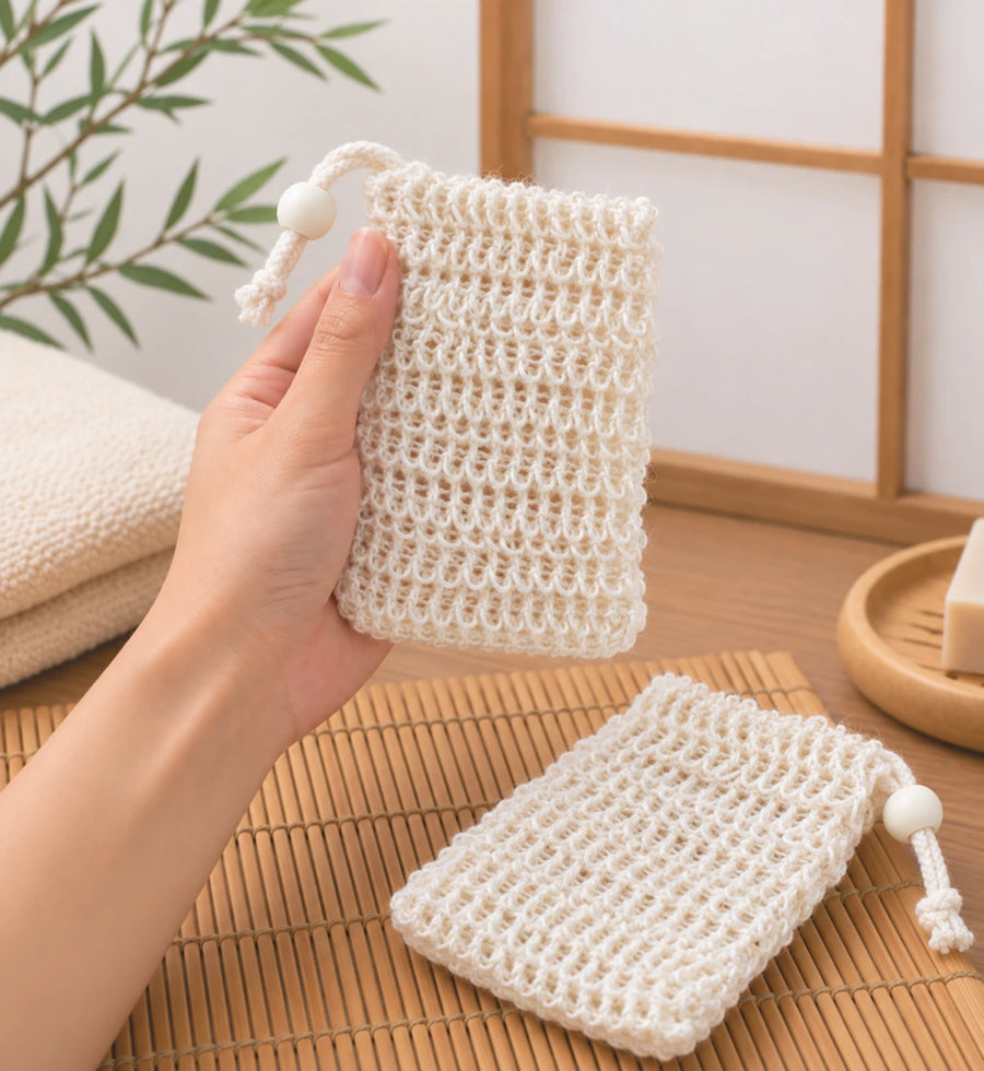 Main tenant un filet à savon en fibres naturelles dans une salle de bain japonaise