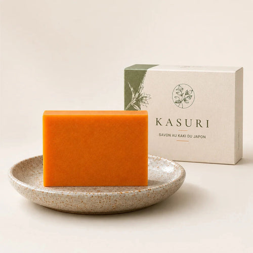 Savon orange au kaki du Japon Kasuri dans une coupelle en céramique, devant son étui